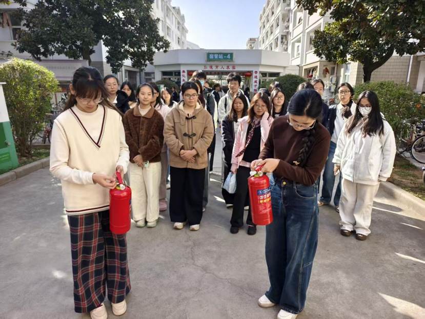 图为活动参与人员练习灭火器的使用。窦美萍供图