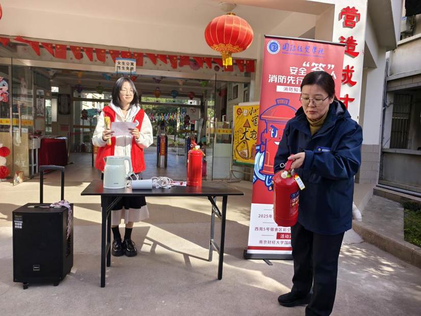 图为宿管周阿姨示范使用灭火器。窦美萍 供图