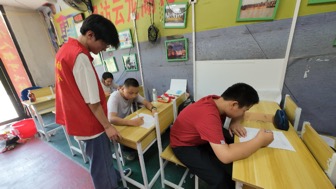 02图为队员吕岩协助孩子们填写调查问卷