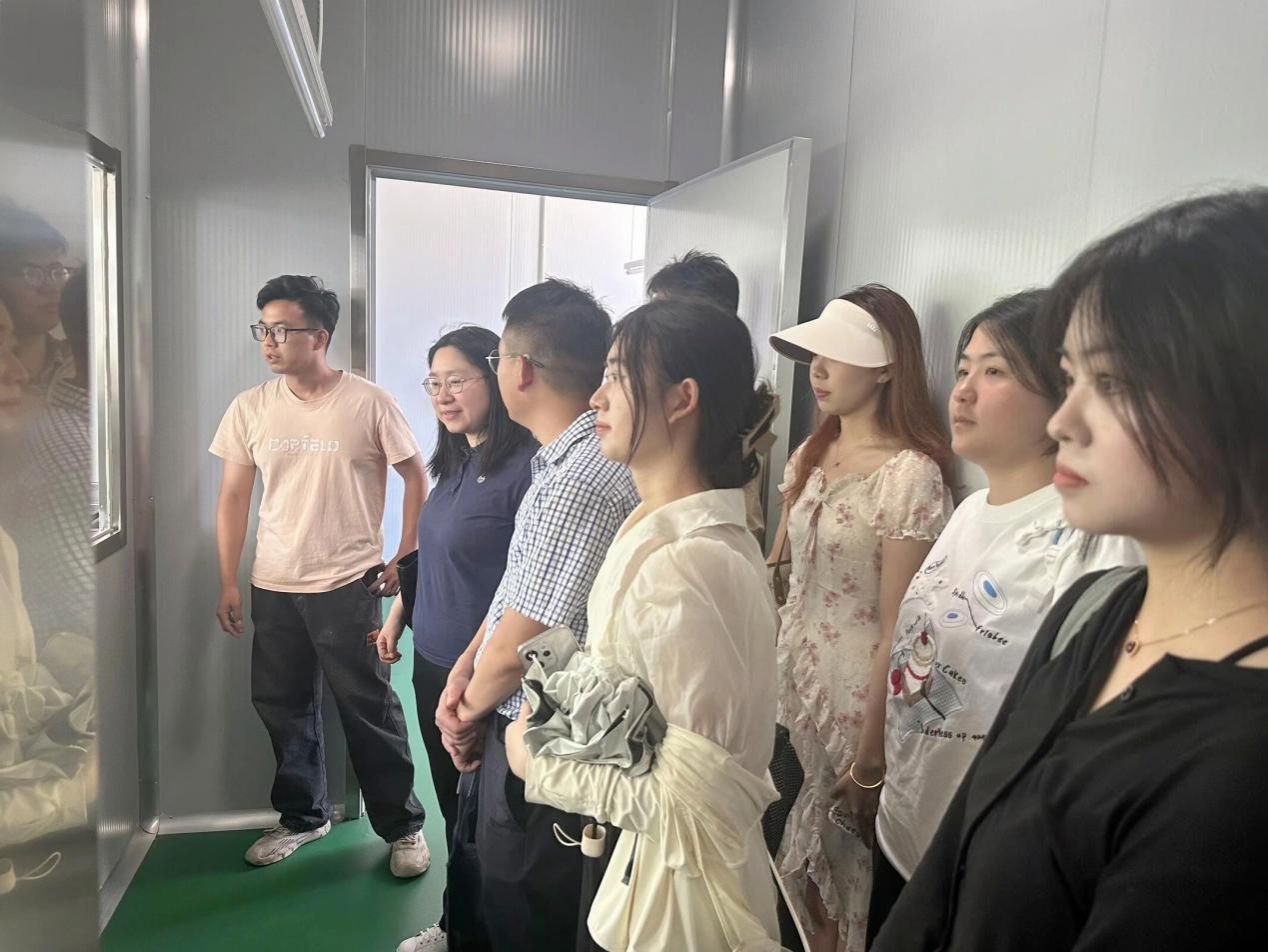 01图为负责人带领团队成员参观加工车间。艾思语供图