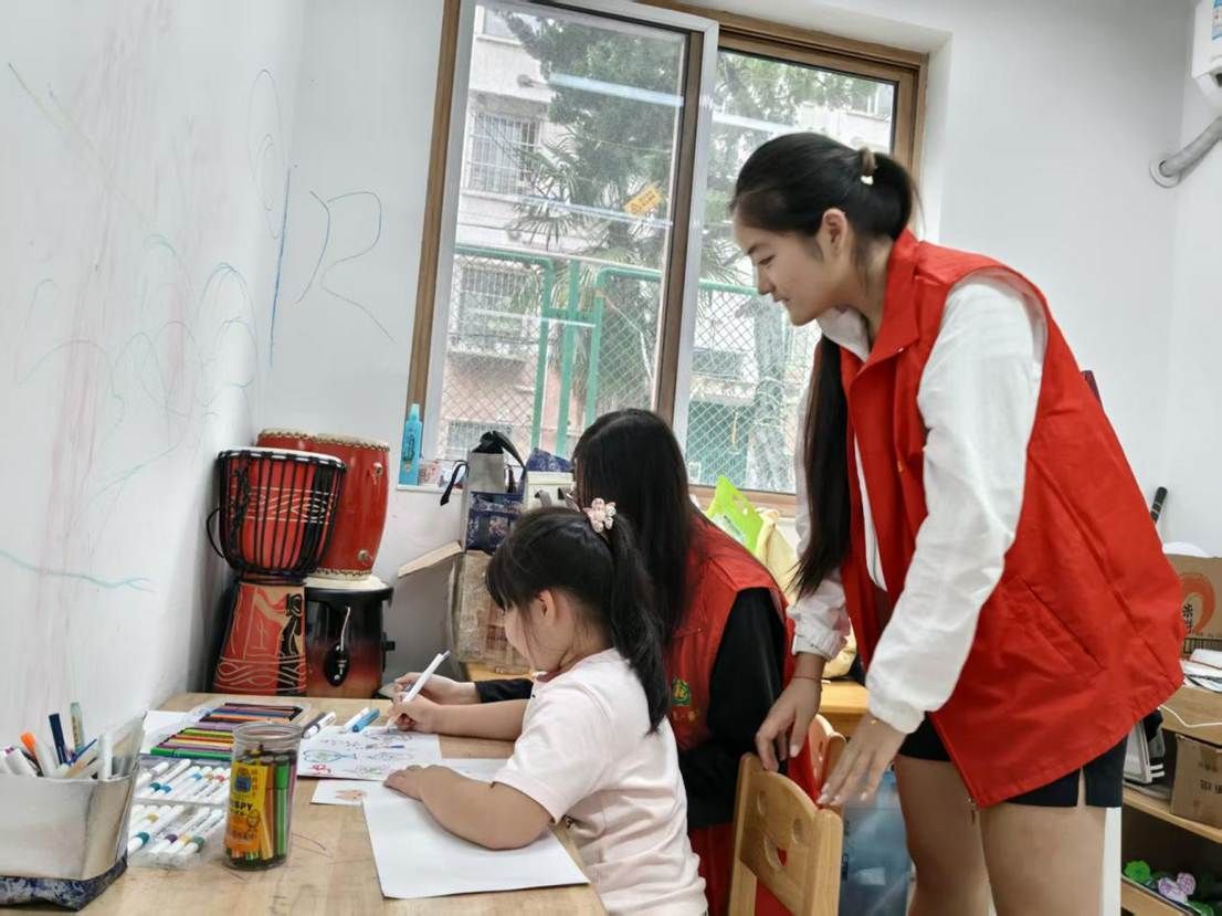 02图为实践队员陪伴孩子画画。 凤语嫣供图