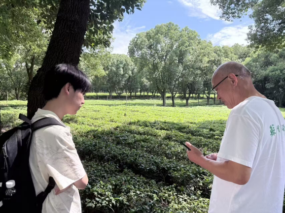 图为参观茶厂时团队队员与茶厂负责人进行交流 赵越供图