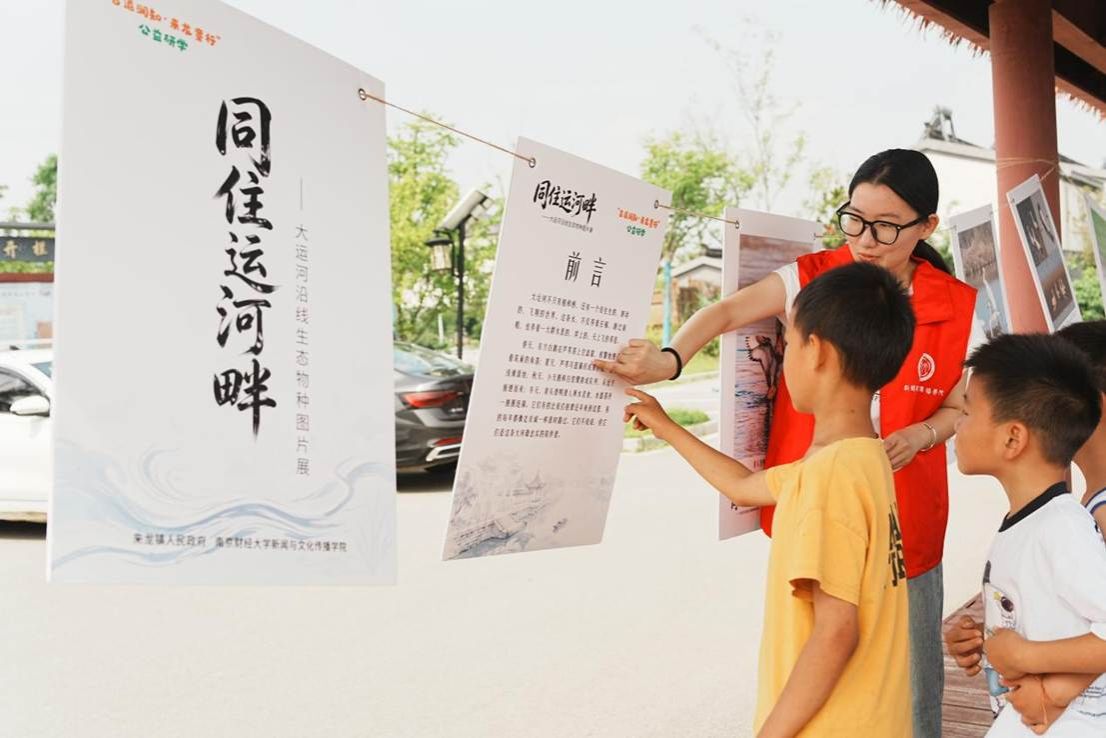 01图为志愿者向儿童讲解大运河沿线生态物种图片展 张贤供图